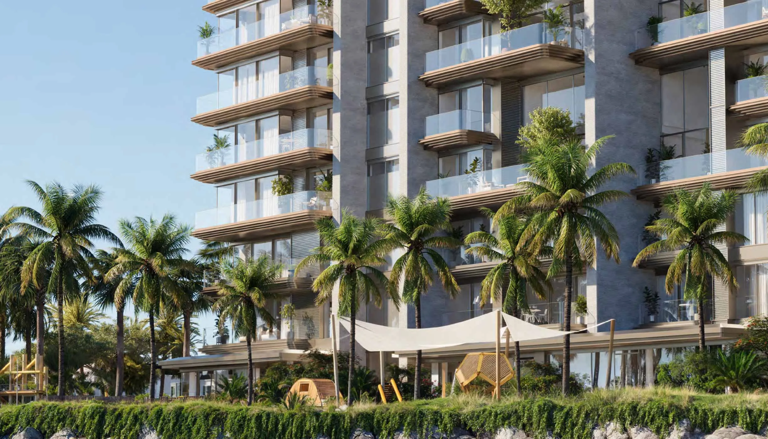 Solaya building facade with palms and a shaded children's play area